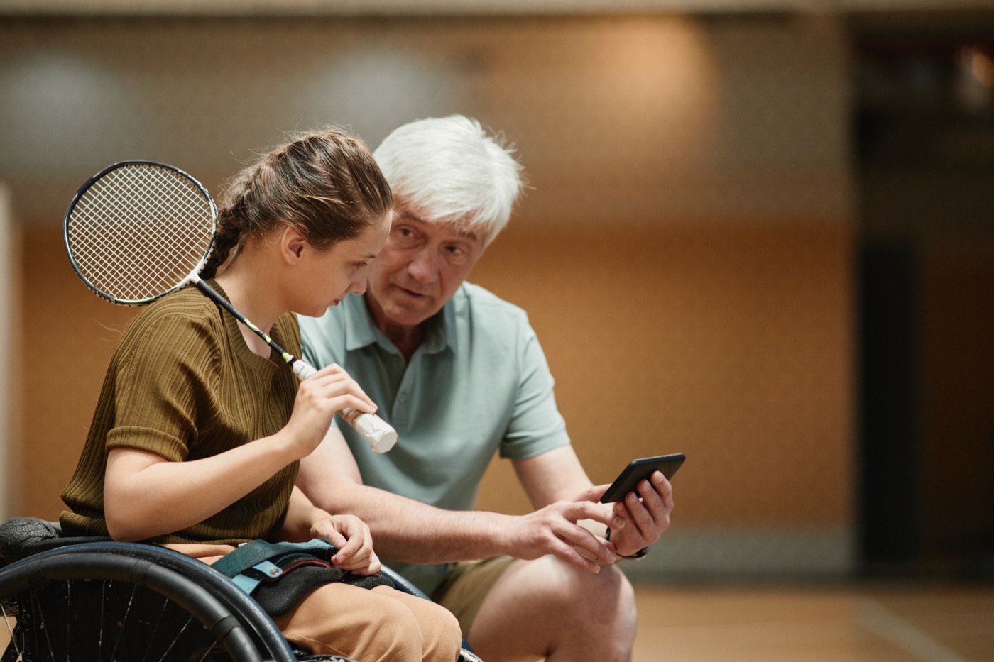 Treinador a mostrar o plano de treino num tablet a um atleta
